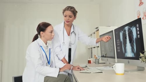 Doctors Consulting with X-Ray on Computer Screen