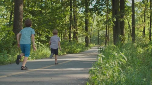 Sibling running on park pathway.
