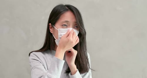 Woman Puts on Face Mask for Protection