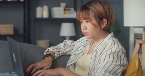 Young Woman Typing on a Laptop at Home