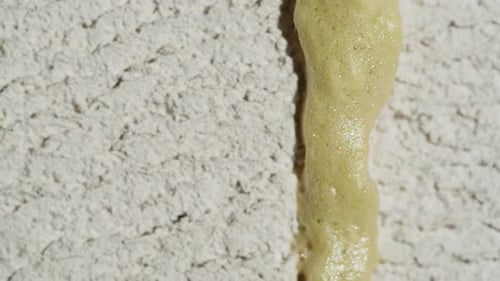 Green Foam Oozing Down Textured White Wall