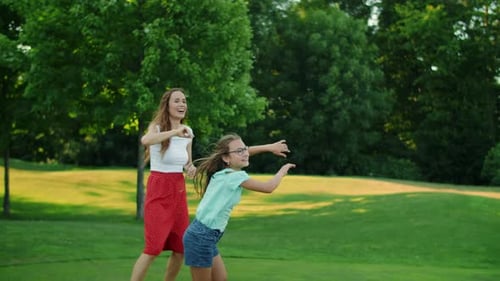 Family Playing with Ball in Summer Park. Positive Parents Throwing Ball in Air