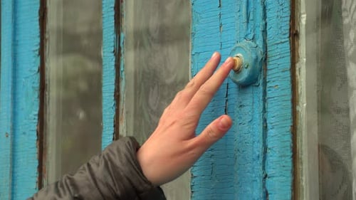 Hand Rings Vintage Doorbell on Blue Wood Door