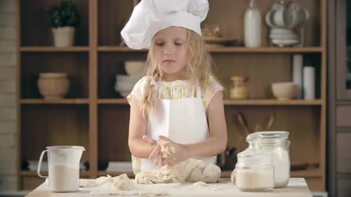 Young Girl Kneading Dough in Kitchen