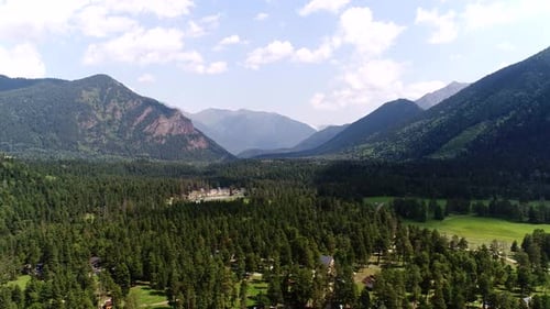 Aerial View Houses and a Suburban Village in the Forest Against the Backdrop of Mountains