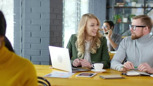 Colleagues Discussing Work on Coffee Break in Cafe