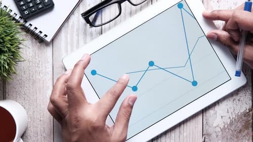 Man's Hand Working on Digital Tablet at Office Desk, Using Self Created Chart