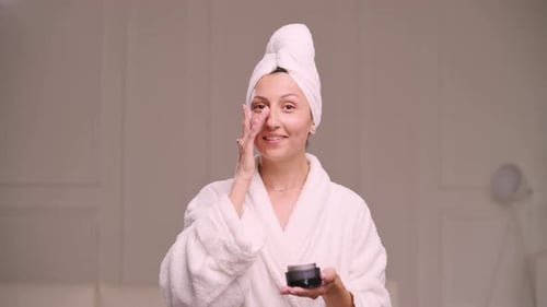 Woman Applies Cream to Face