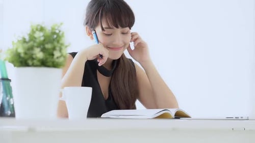 Woman Writing in Notebook at Bright Desk
