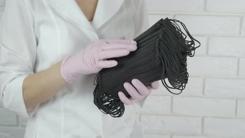 Person Holding Black Face Masks in Gloves