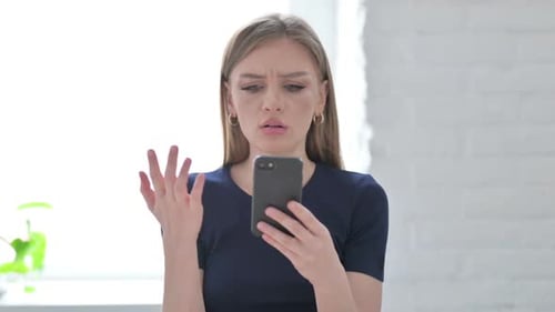 Frustrated Woman Using Smartphone Indoors