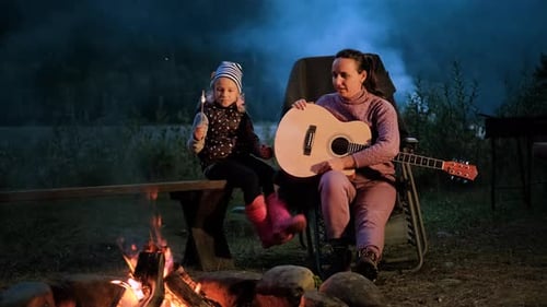 Mother and Child at Campfire with Guitar