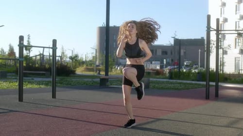 Young Beautiful Brunette Woman with Flowing Hair Does Run in Place Warming Up Before Workout on