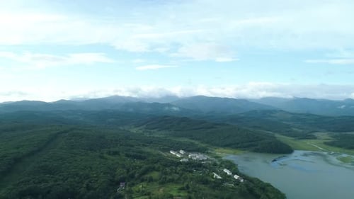Aerial Drone View of Beautiful Natural Scenery of Green Hills Houses and Lake Mountains in