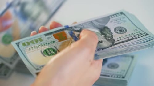 Hands Counting Stacks of One Hundred Dollar Bills