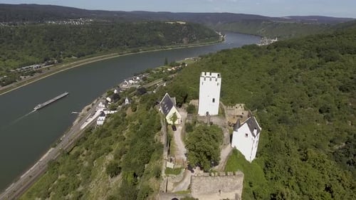 Drohnenflug in der Nähe einer alten Burg auf einem Berg oberhalb eines deutschen Dorfes.