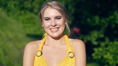 Blonde Woman Smiling in Yellow Dress Outdoors