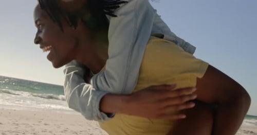 Man giving piggyback ride to woman on the beach 4k