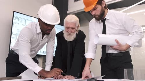 Architects Reviewing Building Plans in Office