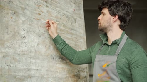 Painter Man Working in a Modern Abstract Oil Canvas in His Studio