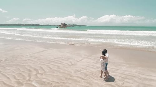 Couple Standing On A Sandy White Tropical Beach