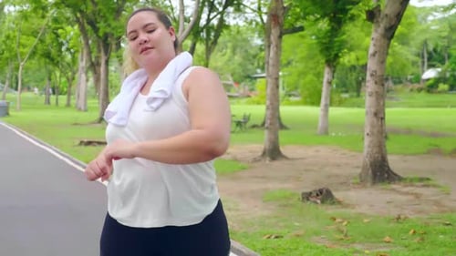 Overweight young woman exercising to lose weight in the park