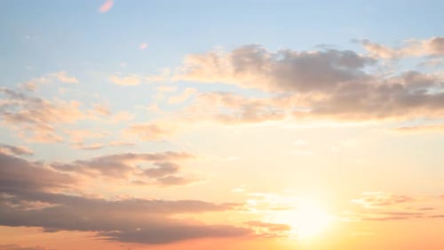 Sun Sunshine Through Sunset Sky. Bright Dramatic Sky With Fluffy Clouds. Yellow, Orange, Blue And