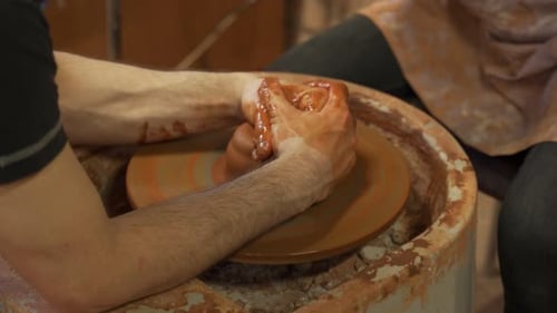 L'homme potier qui enseigne l'art de fabriquer des pots à une femme
