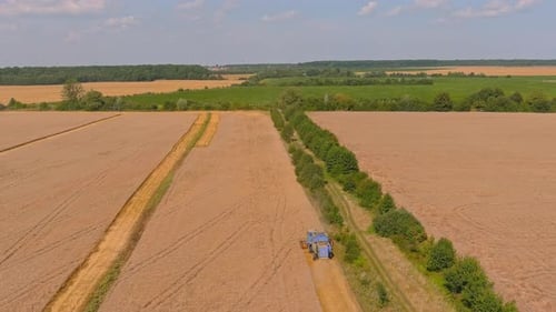 Aerial View of Tractor Cultivating Rural Golden Field