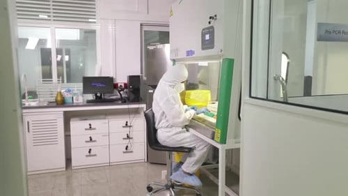 Lab Worker in Full Protective Suit Performing Research