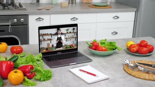 Laptop Showing Cooking Tutorial in Modern Kitchen