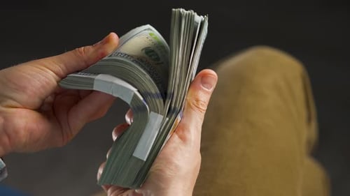 Hombre revisa billetes de dólares estadounidenses