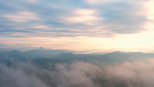 4K Flying through the clouds above mountain tops