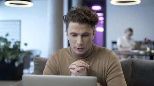 Young Adult Man Video Conferencing on Laptop