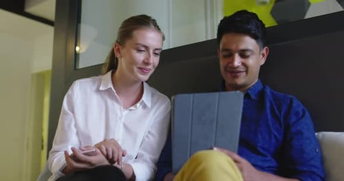 Coworkers Viewing a Tablet in a Modern Office