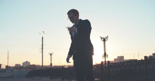 Businessman Celebrates Victory at Sunset, Throwing Documents