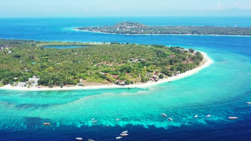 Beautiful curved shore of tropical island surrounded by white sandy beach and large turquoise lagoon