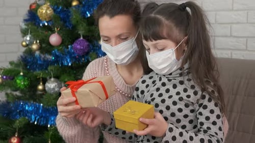 Mother and Daughter with Christmas Gifts Wearing Face Masks