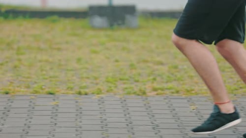 Legs of a Man Running Along the Path