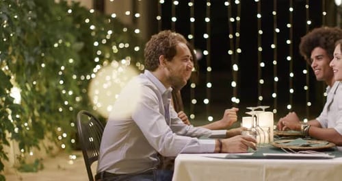 Friends Sharing a Meal Together Outdoors at Night