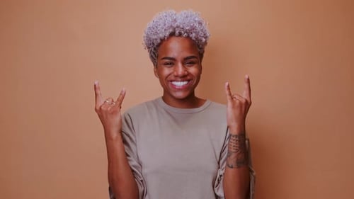 Junge afroamerikanische Rock'n'Roll-Liebhaberin demonstriert Ziegengeste