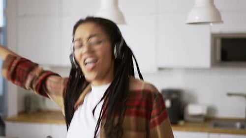 Woman Dancing to Music in Modern Kitchen
