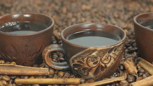 Steaming Coffee in Pottery Mugs with Cinnamon Sticks