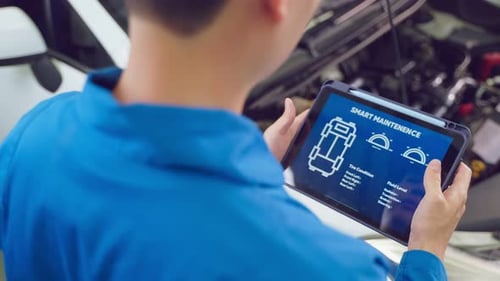 Close up of Automotive mechanic running diagnostics software on tablet.