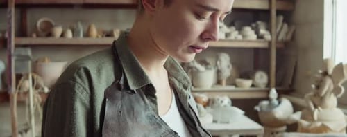Woman Using Smartphone in Pottery Workshop