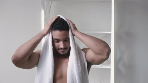 Handsome Man Dries Hair With Towel in Bathroom