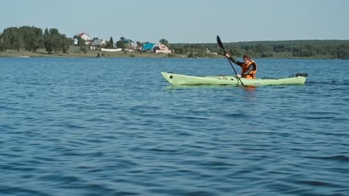 Man Kayaking on Lake During Sunny Day