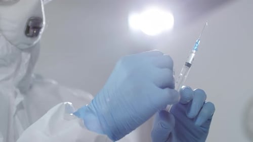 Healthcare Worker Prepares Vaccine Syringe in Lab