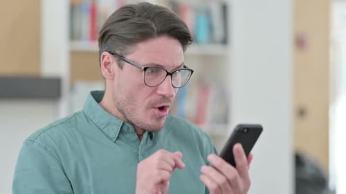 Man with Glasses Reacts to Phone News