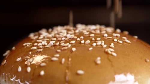 Roasted Sesame Seeds are Sprinkled on Fresh Bun Closeup View